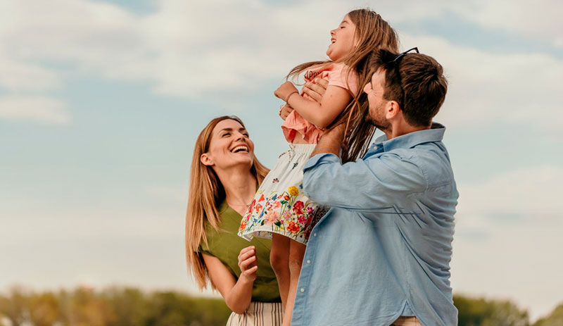 Padre, madre, e hijo pequeño disfrutnado al aire libre