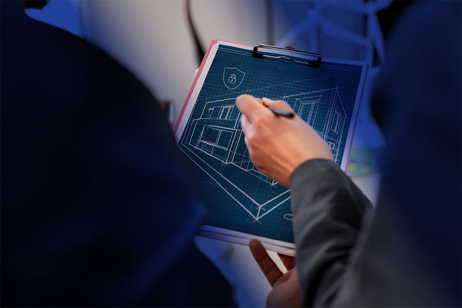 Primer plano de manos de ejecutivos anotando en papel planos de edificios