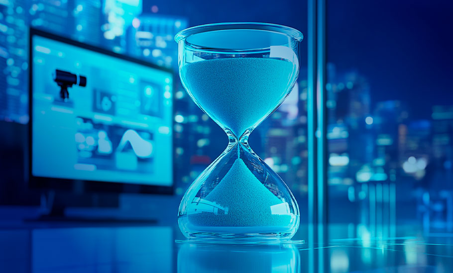 Primer plano de reloj de arena de cristal con monitor de fondo todo en tonalidad azul